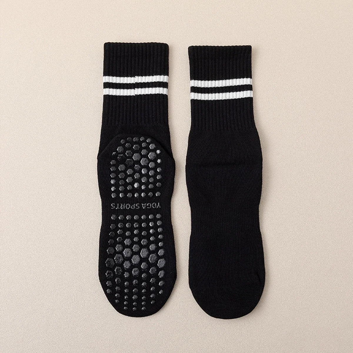 Pair of black grip socks with white stripes and studded soles for yoga and barre