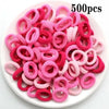 Haufen von 500 rosa und magentafarbenen Nylon-Haargummis für Pferdeschwänze und Zöpfe.