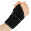 A hand wearing a black, elastic wrist support brace for pain relief.