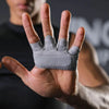 A hand wearing gray ergonomic anti-slip gym lifting gloves, shown in a close-up view.