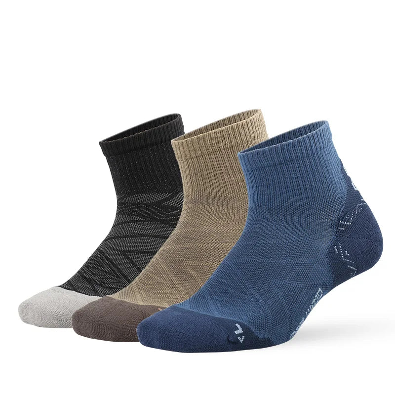 A stack of four breathable performance running socks in shades of black, gray, beige, and navy blue.