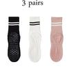 Three pairs of grip socks for yoga and barre, featuring black, white, and pink colors.