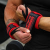 Gros plan sur le poignet d'une personne portant un bandage de musculation rouge et noir.