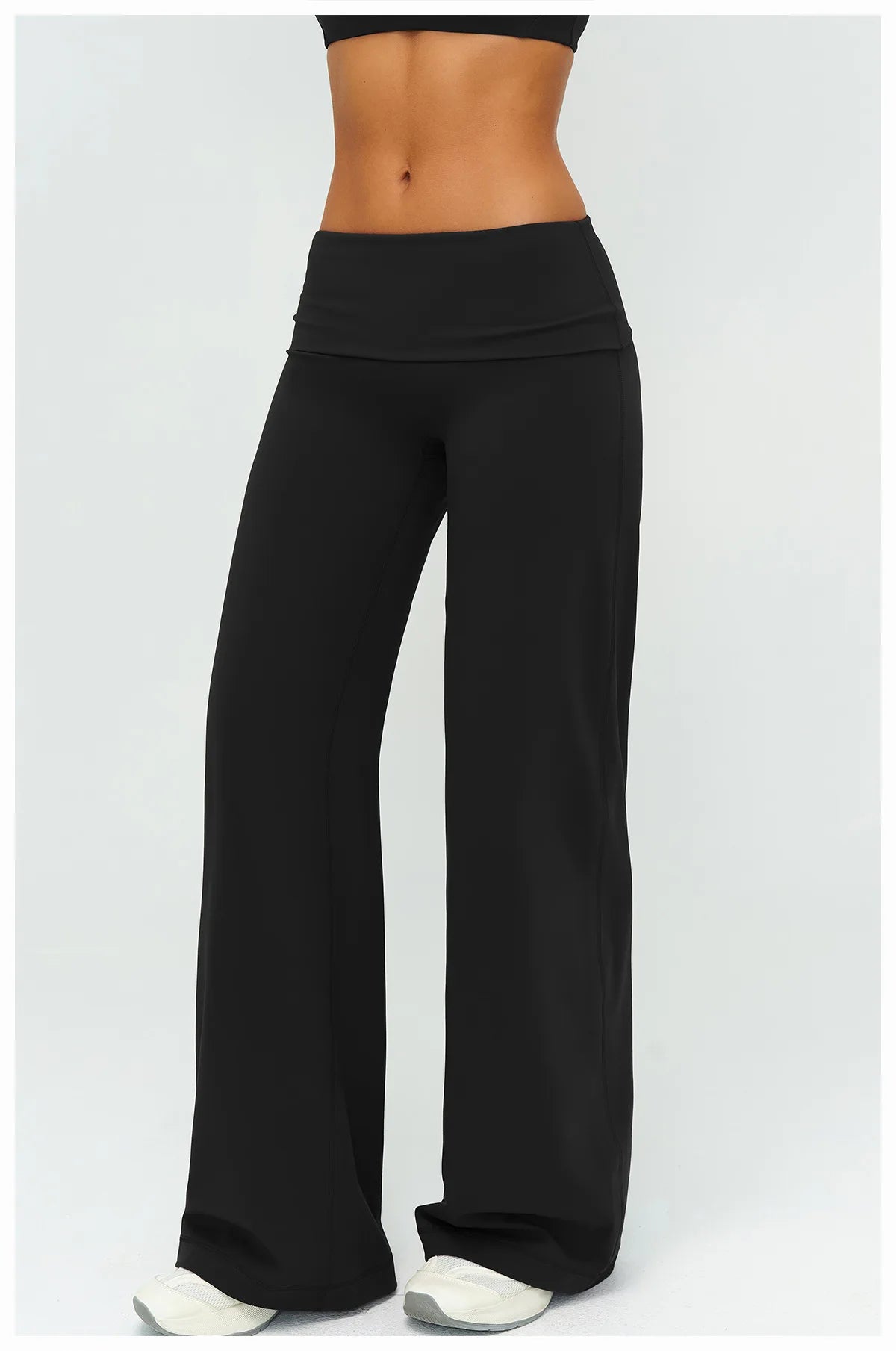 Black flared high-waist yoga pants worn by a model.