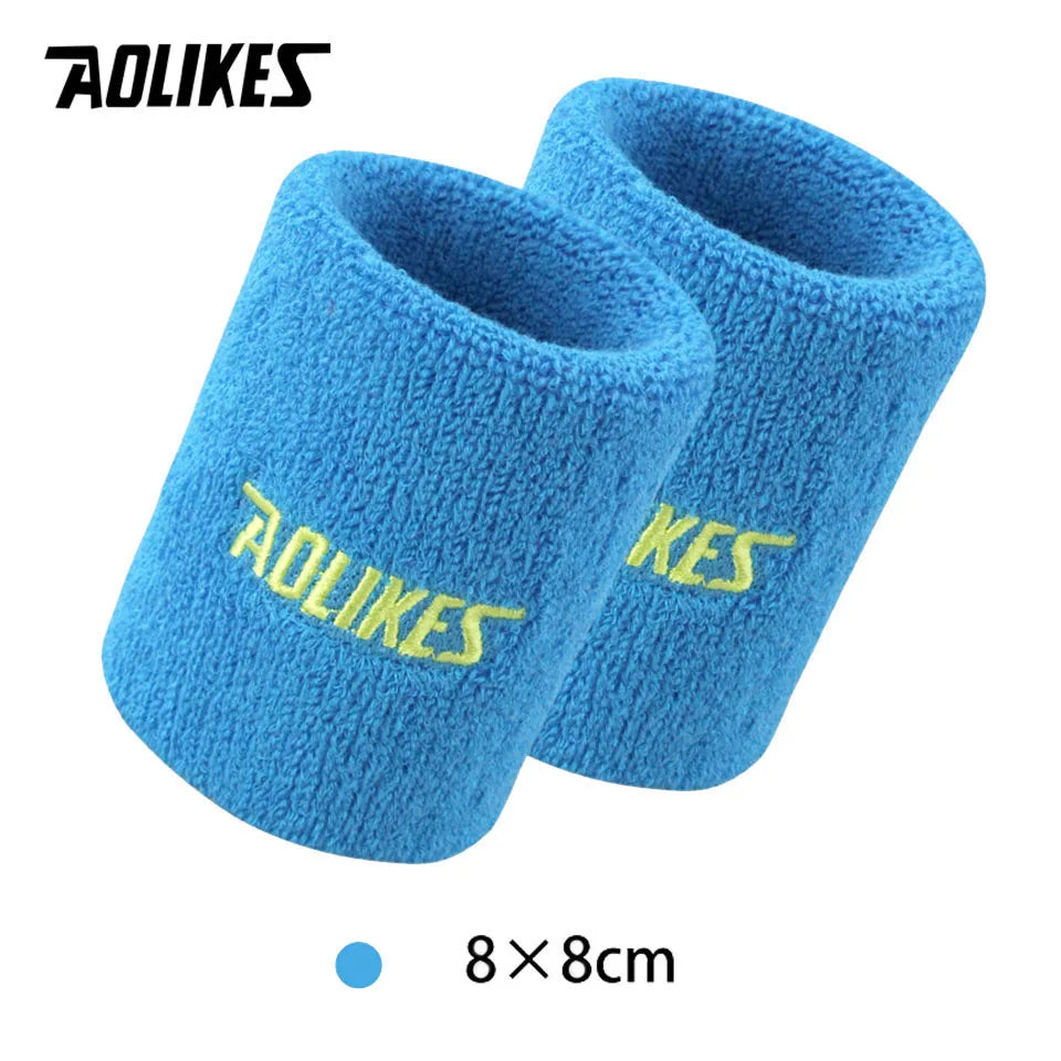 A pair of blue fuzzy wristbands for sport or activewear, shown from the side.