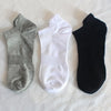 Mehrpack von drei Knöchelsocken in Grau, Weiß und Schwarz auf weißem Untergrund