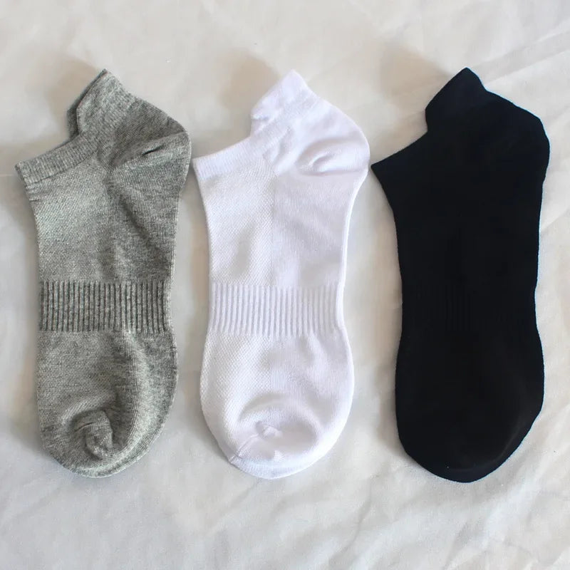 Mehrpack von drei Knöchelsocken in Grau, Weiß und Schwarz auf weißem Untergrund