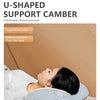 A person is lying down using a U-shaped support camber pillow for neck and head support.