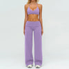 A woman wearing a purple women's premium fitness tracksuit top and matching pants.
