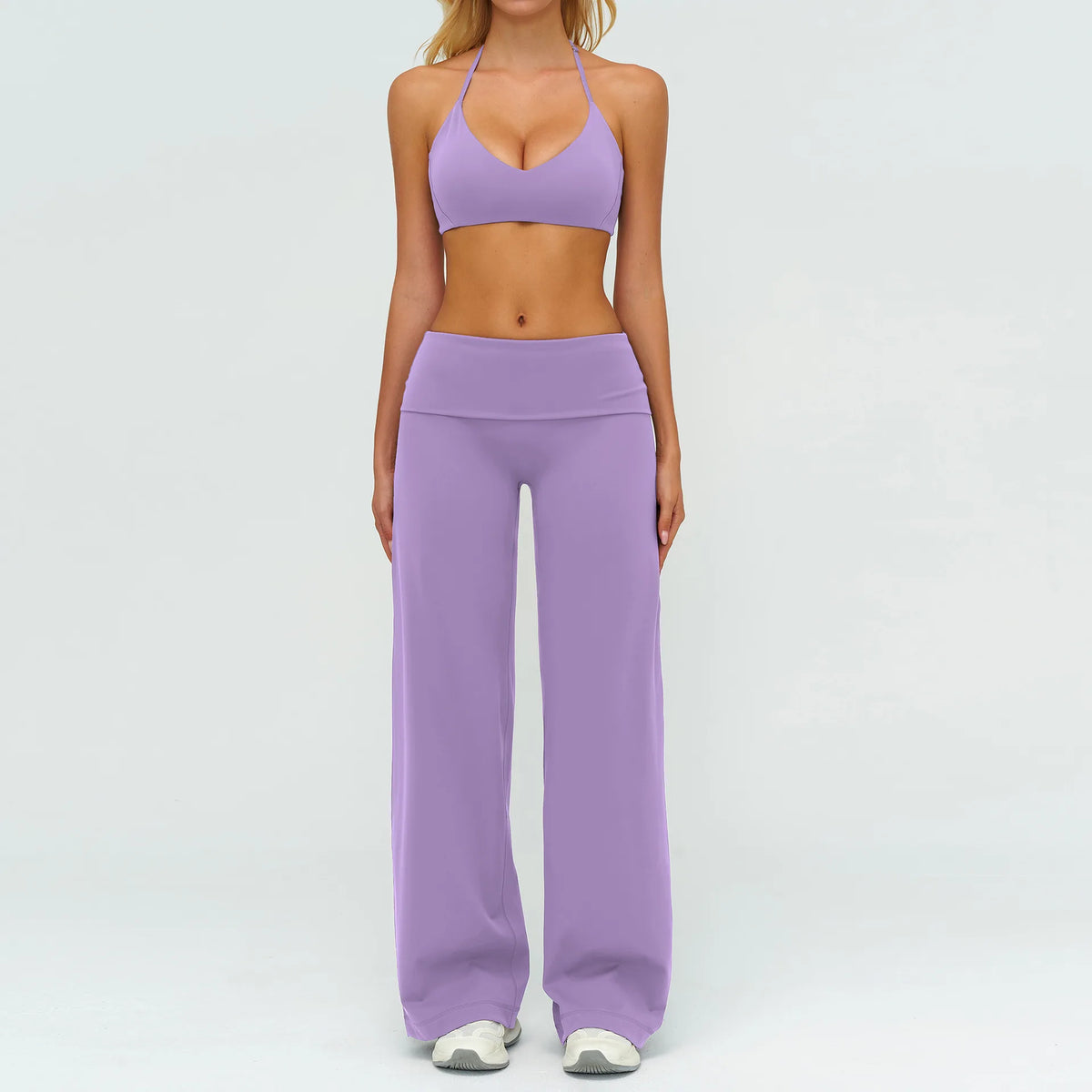 A woman wearing a purple women's premium fitness tracksuit top and matching pants.