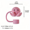A pink silicone straw cover shaped like a small creature, with a loop and a base.