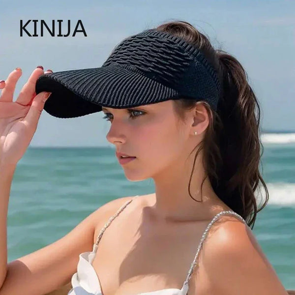 A woman wearing a black breathable anti-UV adjustable sun hat outdoors near the sea.