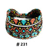 A black and orange patterned boho cotton turban headband worn around the head.