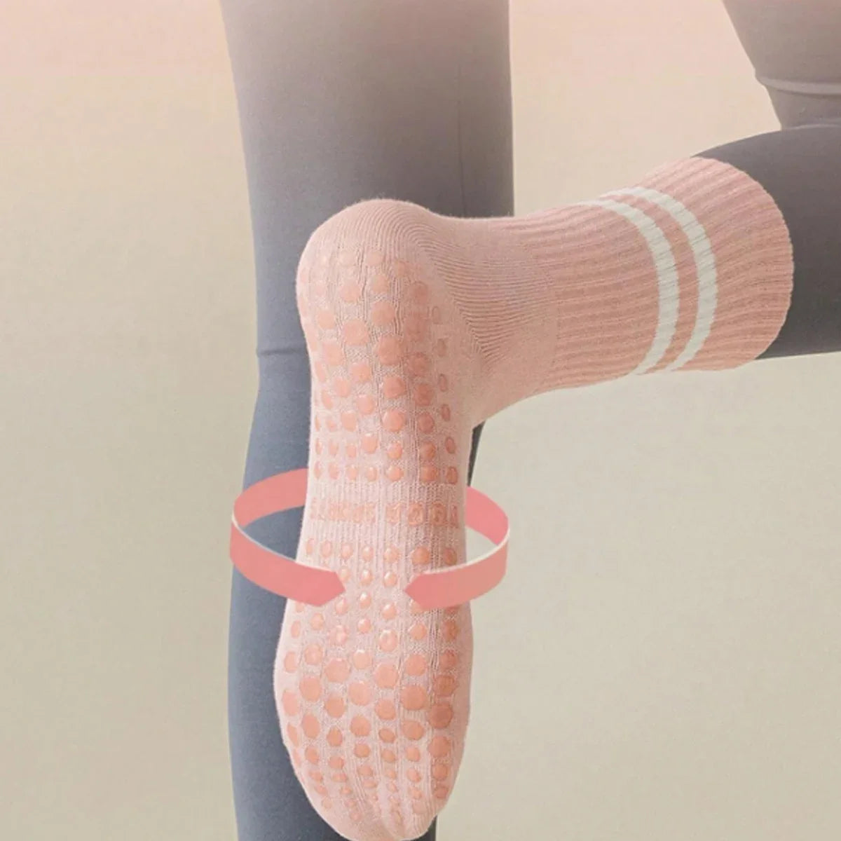 Pink grip socks with white stripes worn on a foot, shown in a close-up view.