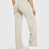 A model is wearing beige high-waist yoga pants in a full-length shot.