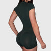 A woman wearing a dark green seamless yoga set with short sleeves and leggings.