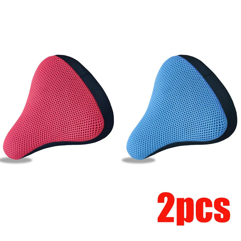 A pair of breathable 3D mesh bicycle saddle cushions in pink and blue.