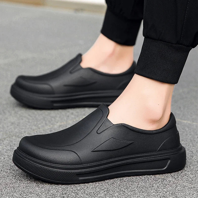 A pair of black men's anti-slip oil-resistant kitchen clogs shown from the side.