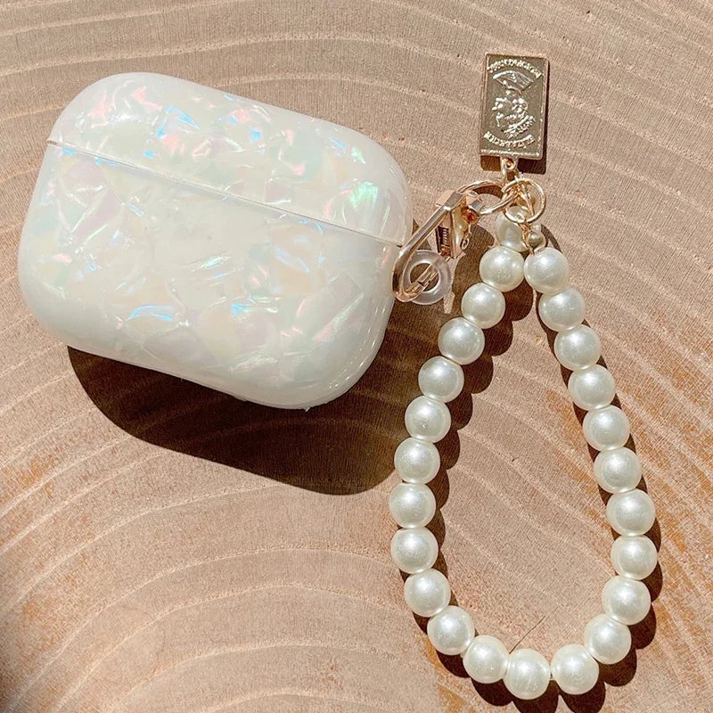 A white leopard pearl protective case for AirPods Pro attached to a gold chain.