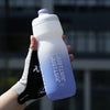 A hand holds a white squeezable cycling water bottle against a dark background.