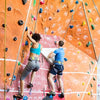 Deux personnes grimpent un mur coloré avec du ruban élastique personnalisable pour le sport et l'escalade.