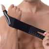 A person is holding a black adjustable thumb and wrist brace with a ruler marked on it.
