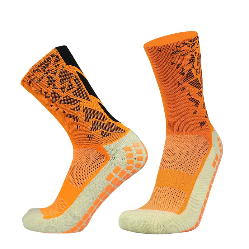 A pair of bright orange anti-slip silicone football socks displayed against a white background.