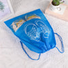 A blue reusable non-woven shoe storage bag with white line drawings of shoes is displayed on a white surface.
