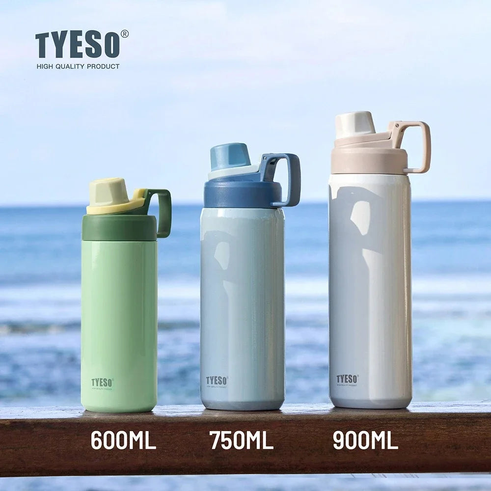 Three sizes of TYESO insulated stainless steel water bottles in light green, blue, and white placed on a wooden surface near 