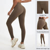 A model wears high-waist yoga leggings in brown, showcasing a seamless fit and slim silhouette.