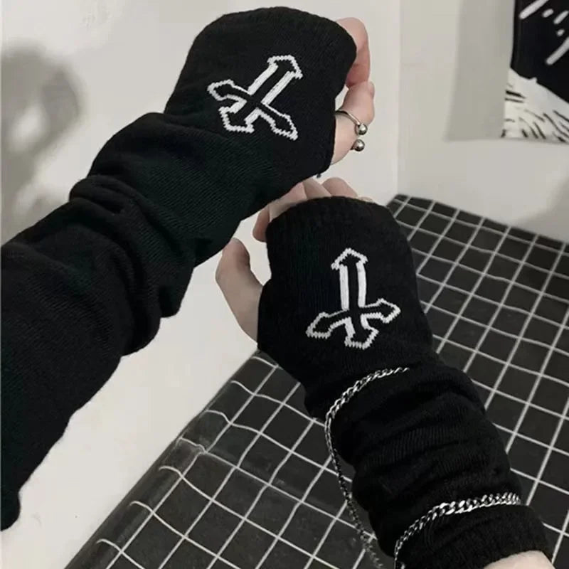 Eine Hand hält einen schwarzen fingerlose Armwärmer mit weißem Kreuzdesign.