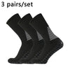 Three pairs of black performance football socks laid out for sale.