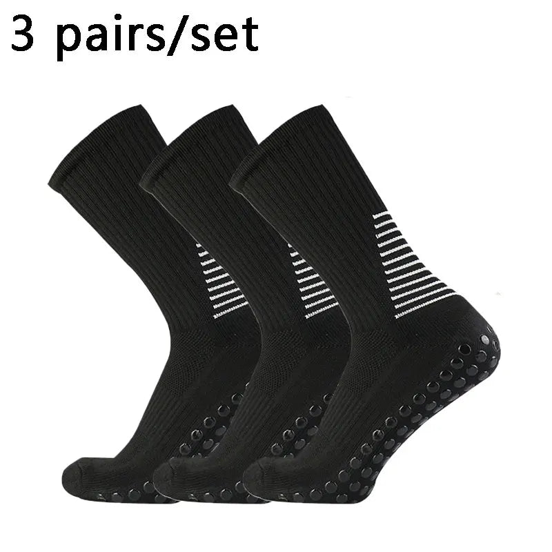 Three pairs of black performance football socks laid out for sale.