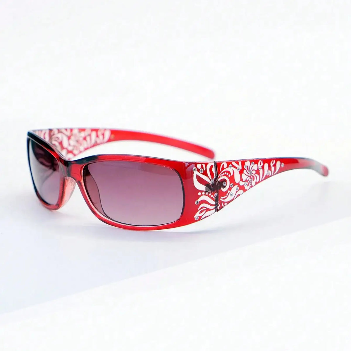Gafas rojas con patrón Y2K blanco en la montura y lentes, vista desde arriba.
