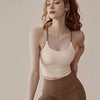 A woman wearing a beige supportive sports bra and matching leggings posing for a photo.