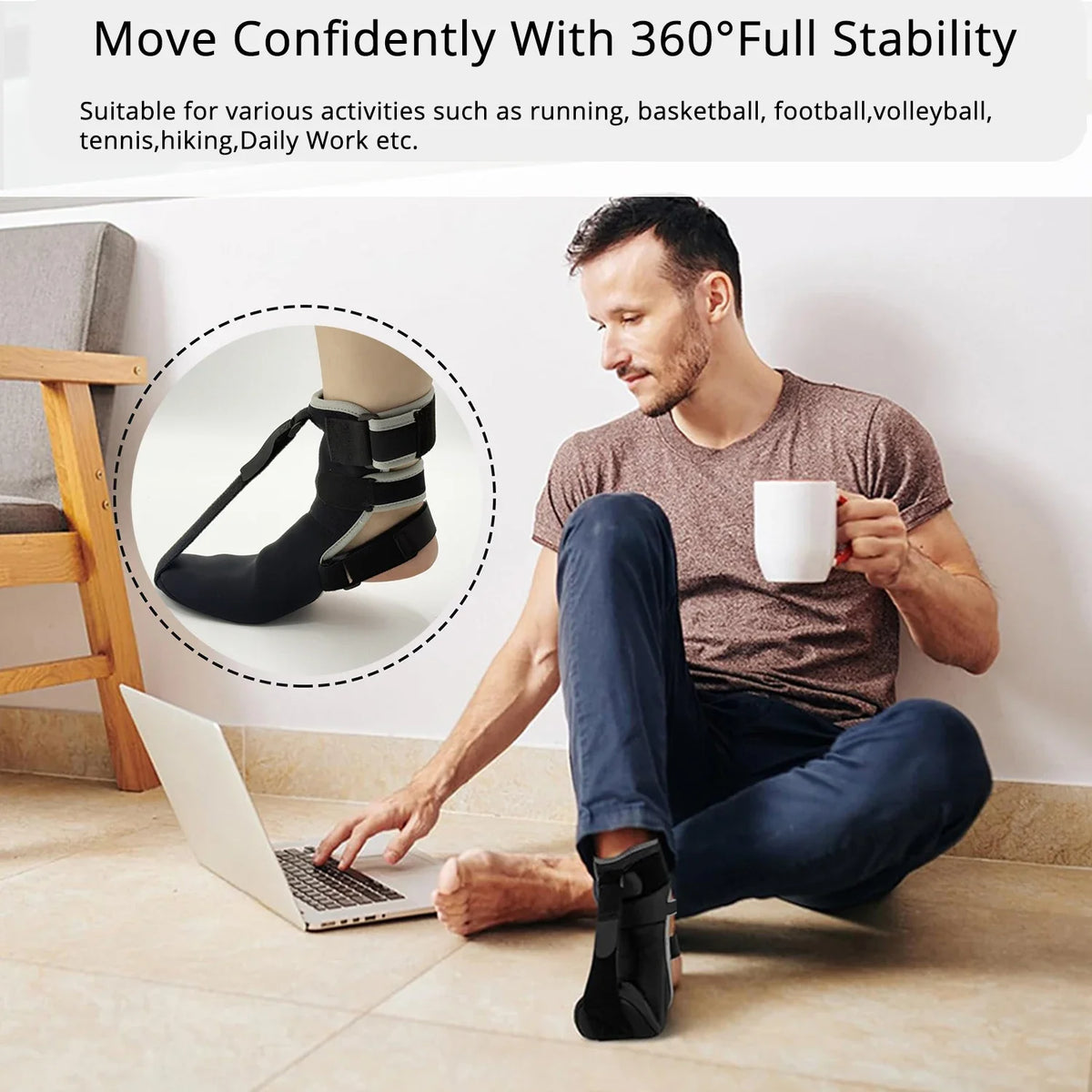 A man is sitting on the floor using a black ankle support device while working on a laptop.