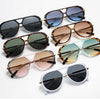 A collection of vintage oversized designer sunglasses in various shades of brown, black, and amber.