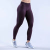A model wearing dark purple high-waisted seamless yoga leggings and light gray athletic shoes.