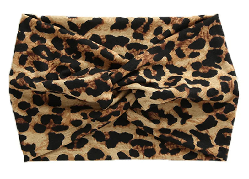 A close-up of a women's elastic sports headband made from brown and black leopard print fabric.
