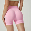 Une femme modélise des shorts de yoga sans couture taille haute, couleur rose pâle.