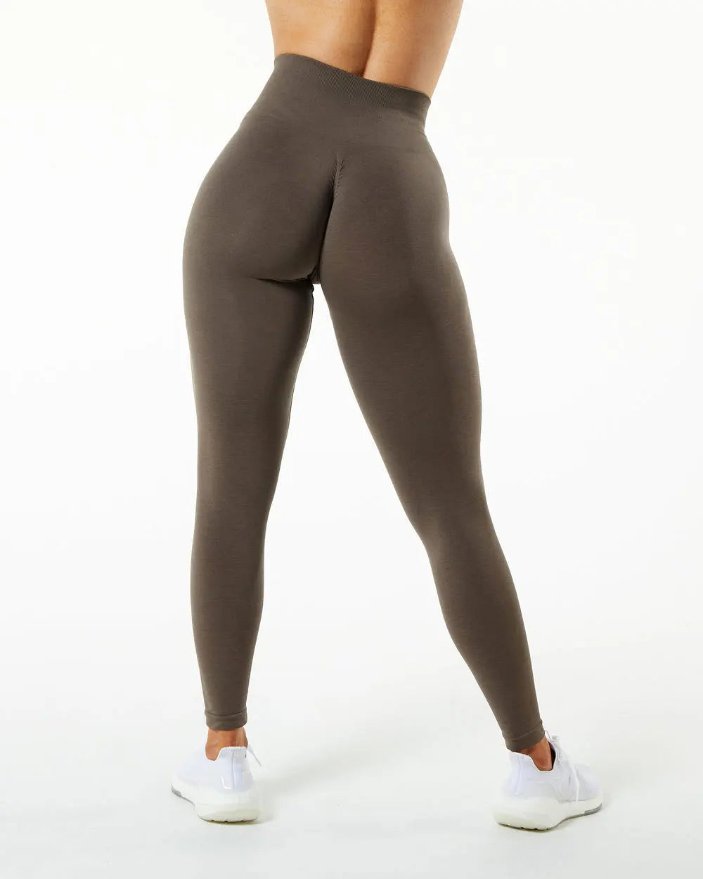 Un mannequin porte un legging de yoga sans couture à taille haute de couleur brun foncé.