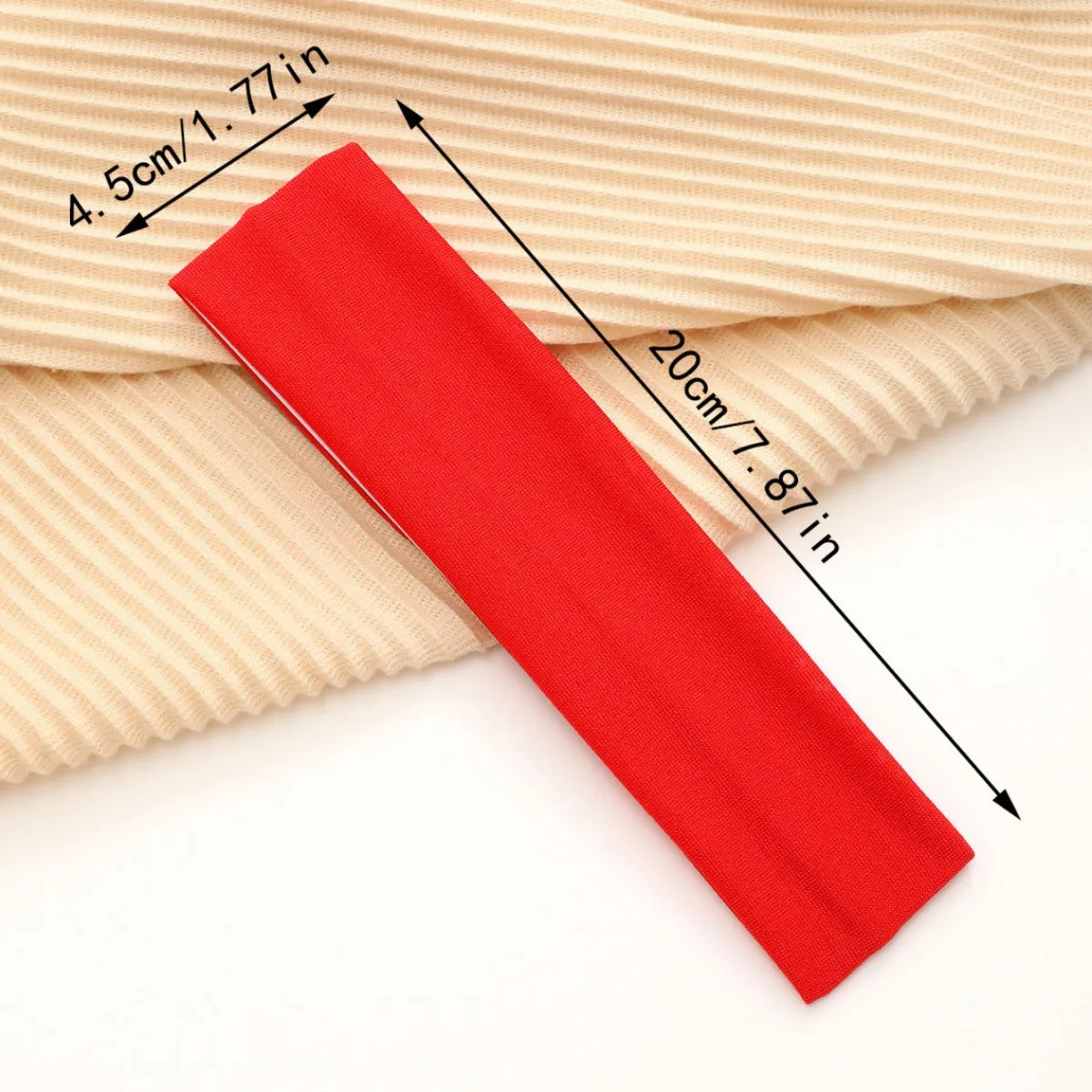 A red elastic headband is shown next to a beige ribbed fabric, illustrating its dimensions.