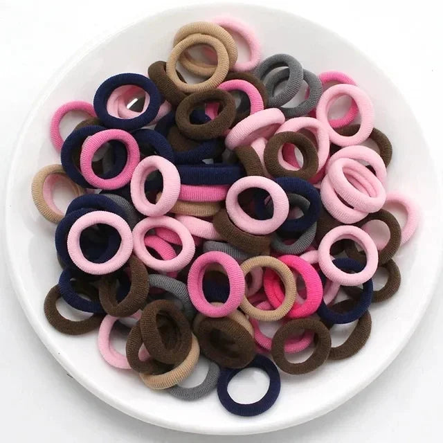 Haufen bunter Nylon-Elastikhaarspangen in verschiedenen Farben wie rosa, lila, braun und grau.