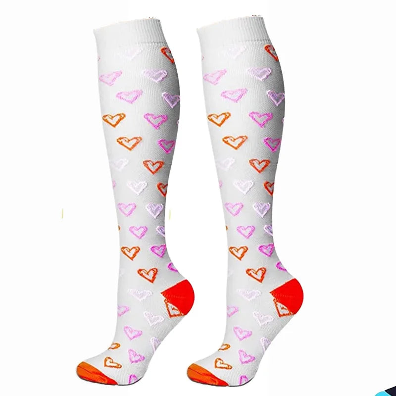 Pair of white compression elastic socks decorated with pink and orange heart patterns