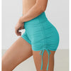 A model wears teal performance yoga shorts with a drawstring waist, highlighting the athletic fit.