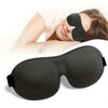 A black memory foam sleep mask is shown being worn by a person, with another mask lying nearby.