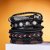 Stapel schwarzer Lederarmbänder mit verschiedenen Anhängern, darunter Feder und Sterne