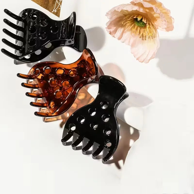A set of three black and amber root lifting hairpin curling clamps shown against a white background.