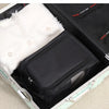 A black shoe carrier bag lined with white faux fur is shown inside an open suitcase.