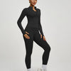 Eine Frau modelliert ein schwarzes Yoga-Sportset mit langärmeligem Oberteil und Leggings.